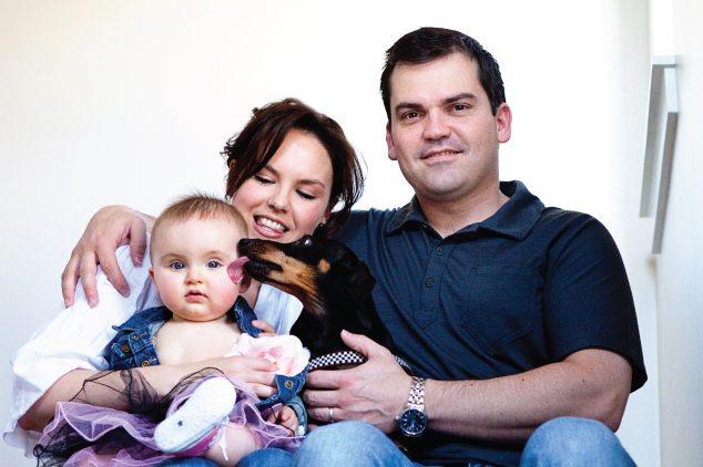 family with dog licking baby