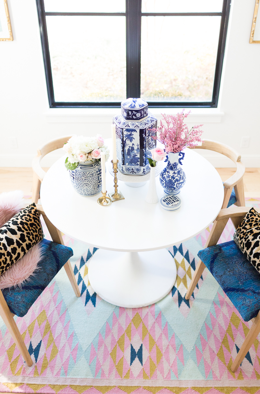 Rooms We Love Home Tour Navy and Pink Modern Glam Breakfast Nook Glittler Guide elodie rug blue and white tabletop vases gold candlesticks black windows wishbone chairs white round table colorful dining room rugs-3.jpg-1.jpg