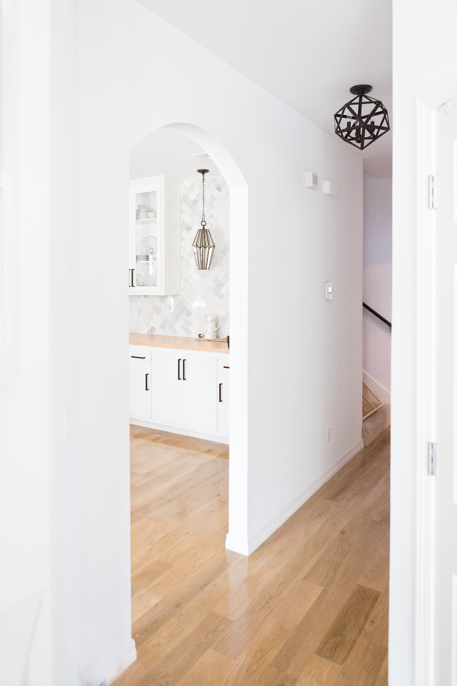 Tulsa Remodel Reveal Modern White Farmhouse black windows and doors butcher block countertops bar marble herringbone backsplash faceted pendant lighting-1