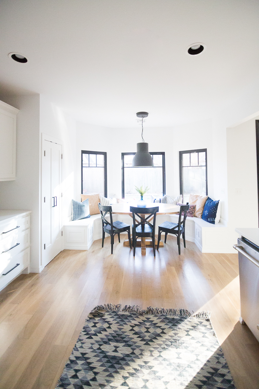 Tulsa Remodel Reveal Modern White Farmhouse with Black WIndows and Doors built in banquette window seat black pendant dining room-1