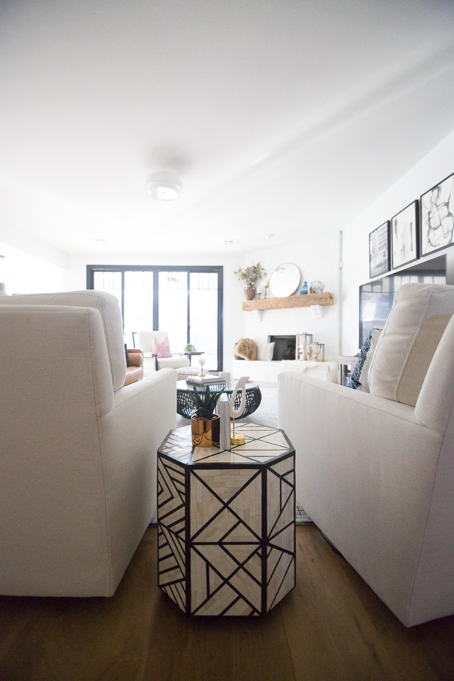 White Painted Brick Fireplace Makeover TV collage wall pottery barn wood media console article sven leather sofa faux fiddle leaf fig tree wood lanterns round gold mirror fireplace styling white walls black windows