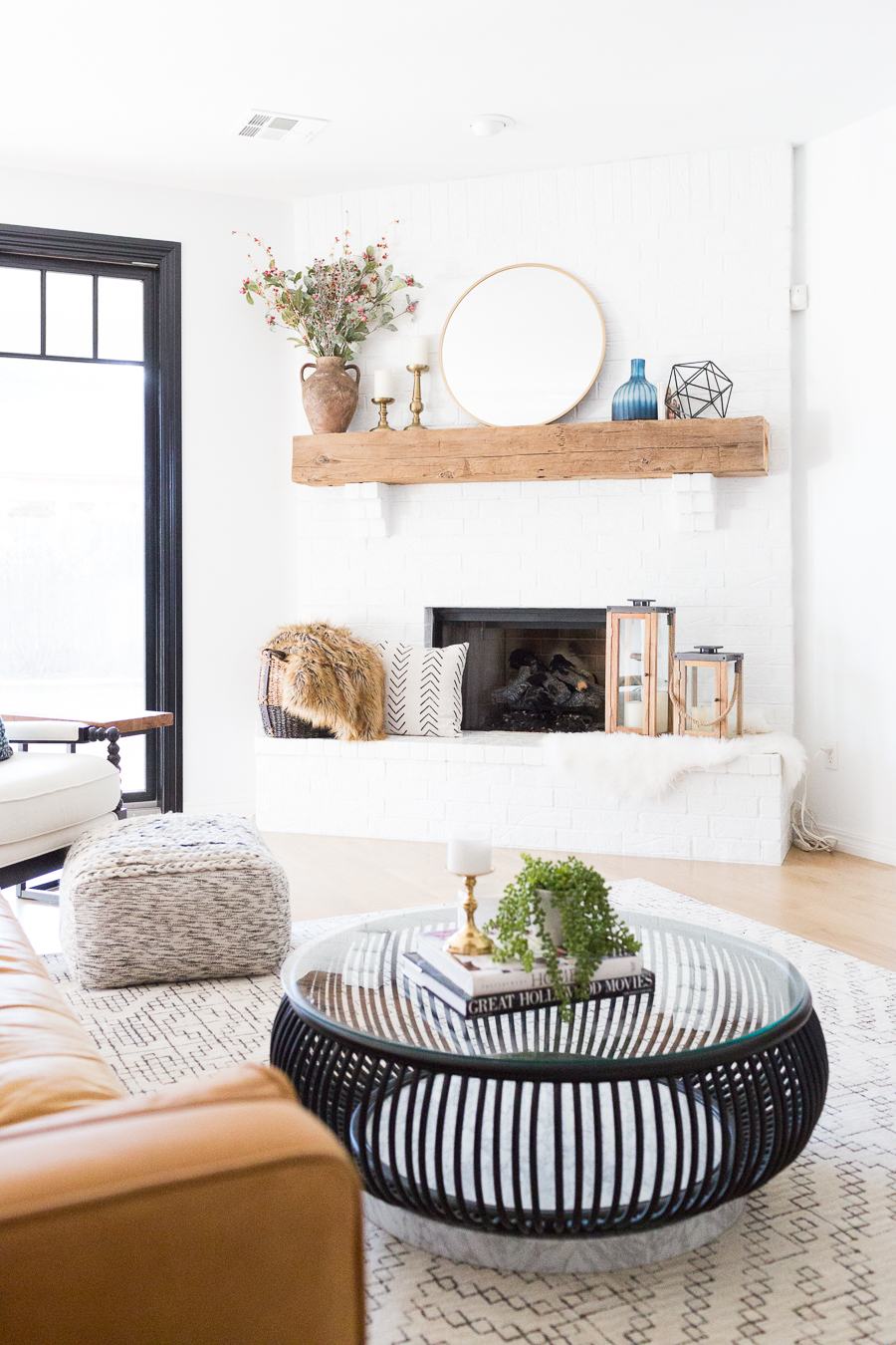 White Painted Brick Fireplace Makeover TV collage wall pottery barn wood media console article sven leather sofa faux fiddle leaf fig tree wood lanterns round gold mirror fireplace styling white walls black windows