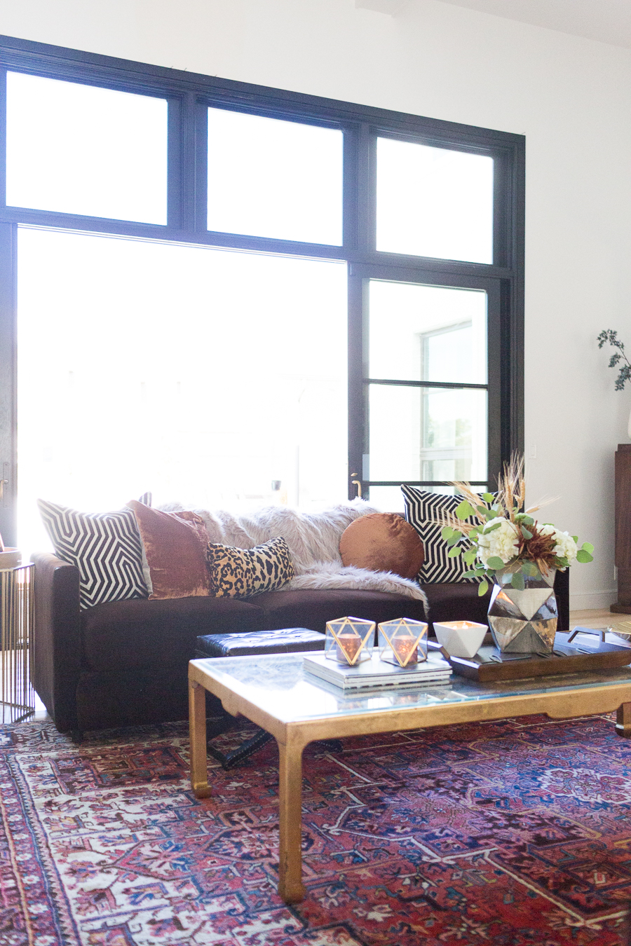 Simple Ways to Decorate for the Holidays from West Elm living room with chocolate velvet couch covered in copper velvet pillows and leopard pillows with a faux fur throw gold coffee table with a wood tray styled for Thanksgiving