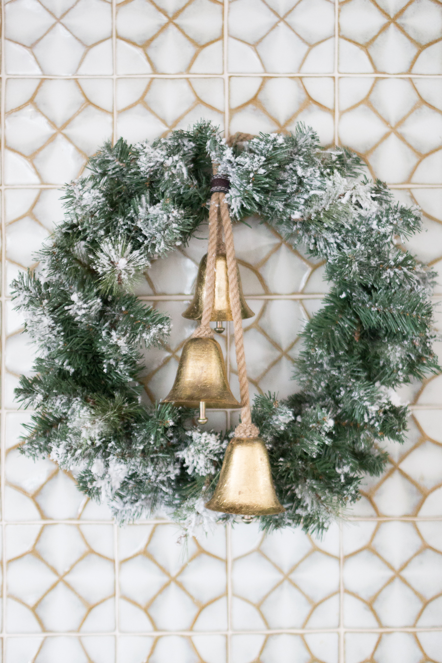 Budget Friendly Holiday Decor from Walmart affordable flocked wreaths with vintage gold bells on ceramic tile backsplash