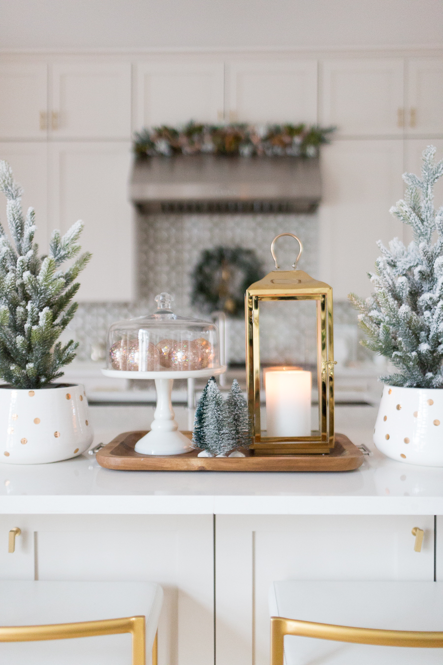 Budget Friendly Holiday Decor from Walmart wood tray with a gold lantern and pioneer woman white cakestand on top of a large quartz waterfall island