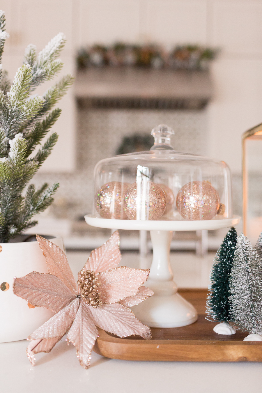 Budget Friendly Holiday Decor from Walmart wood tray with a gold lantern and pioneer woman white cakestand on top of a large quartz waterfall island