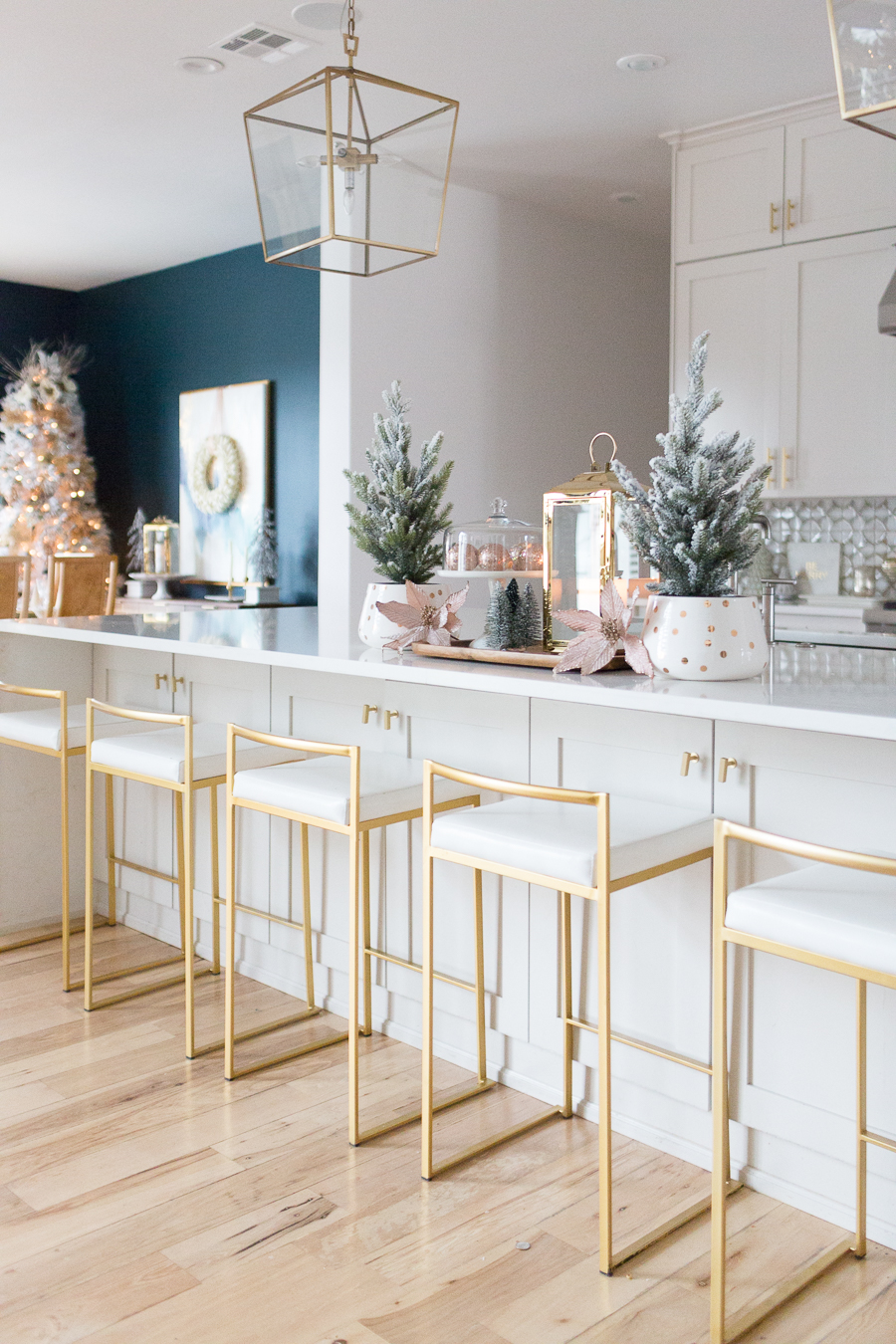 Budget Friendly Holiday Decor from Walmart wood tray with a gold lantern and pioneer woman white cakestand on top of a large quartz waterfall island