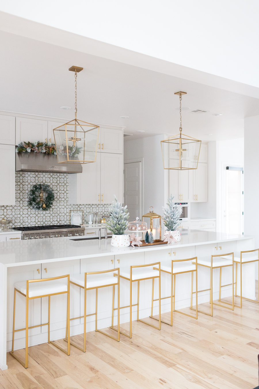 Budget Friendly Holiday Decor from Walmart wood tray with a gold lantern and pioneer woman white cakestand on top of a large quartz waterfall island