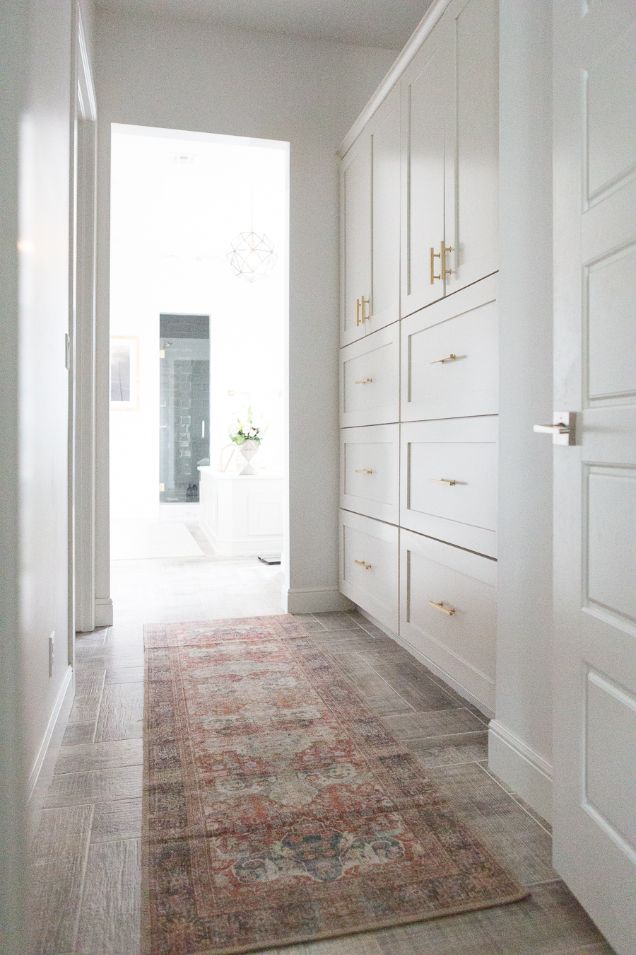 10 Beautiful Kitchen Runners for Your Home multi-colored runner in hallway with white cabinetry on wooden tile flooring