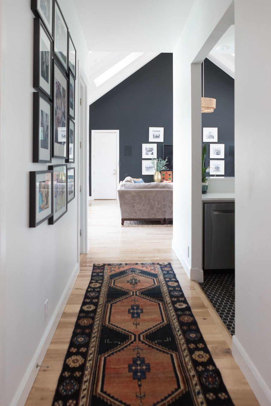 TEEN HANGOUT ROOM DESIGN PLAN AND HANGING CHAIRS looking down the hallway with a dark colored runner and wall art