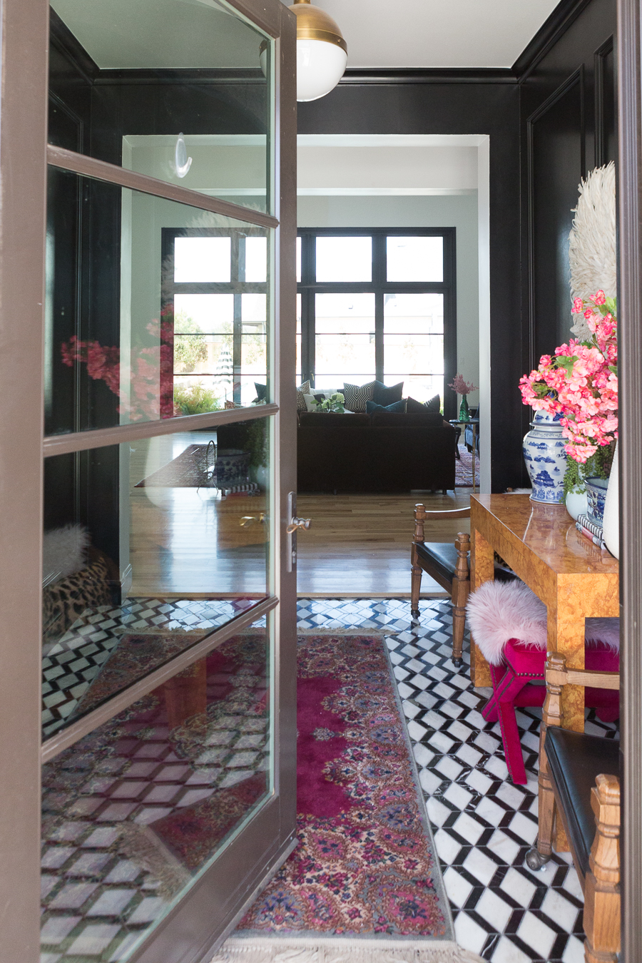 HOW TO FIND BLACK WINDOWS AND DOORS FOR LESS looking in from the front entrance displaying beautiful geometric black and white tile with black painted walls