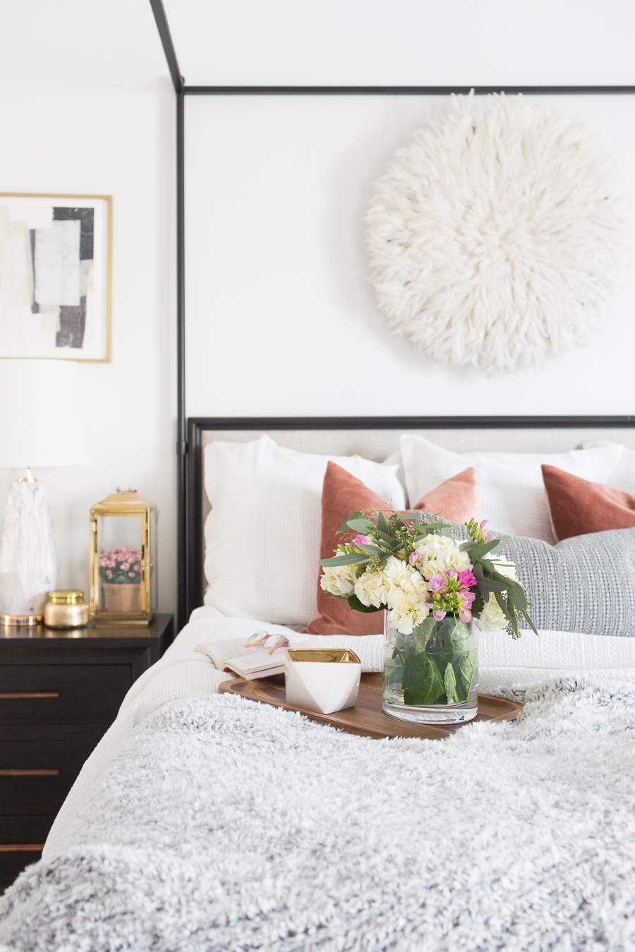 Refresh Your Master Bedroom and Bath with Pottery Barn pastel styled bedroom with black canopy bed and end tables and golden accented decor