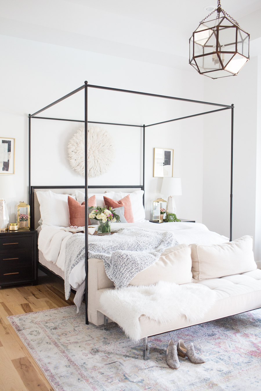 Refresh Your Master Bedroom and Bath with Pottery Barn black canopy bed with whites and pastel colors used in the pillows, bedding, and bench