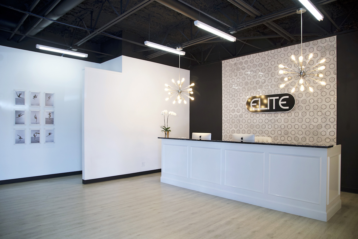 elite dance studio front desk view with beautiful chandeliers and featured wall