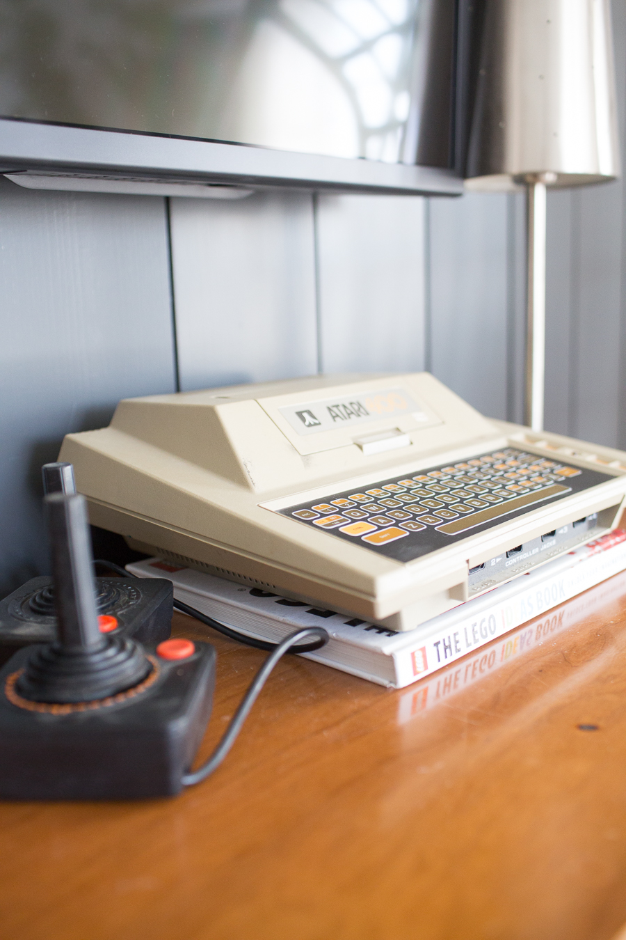 CC and Mike Teen Hangout Room Reveal with Joybird Sectional vintage Atari sitting on a midcentury modern dresser