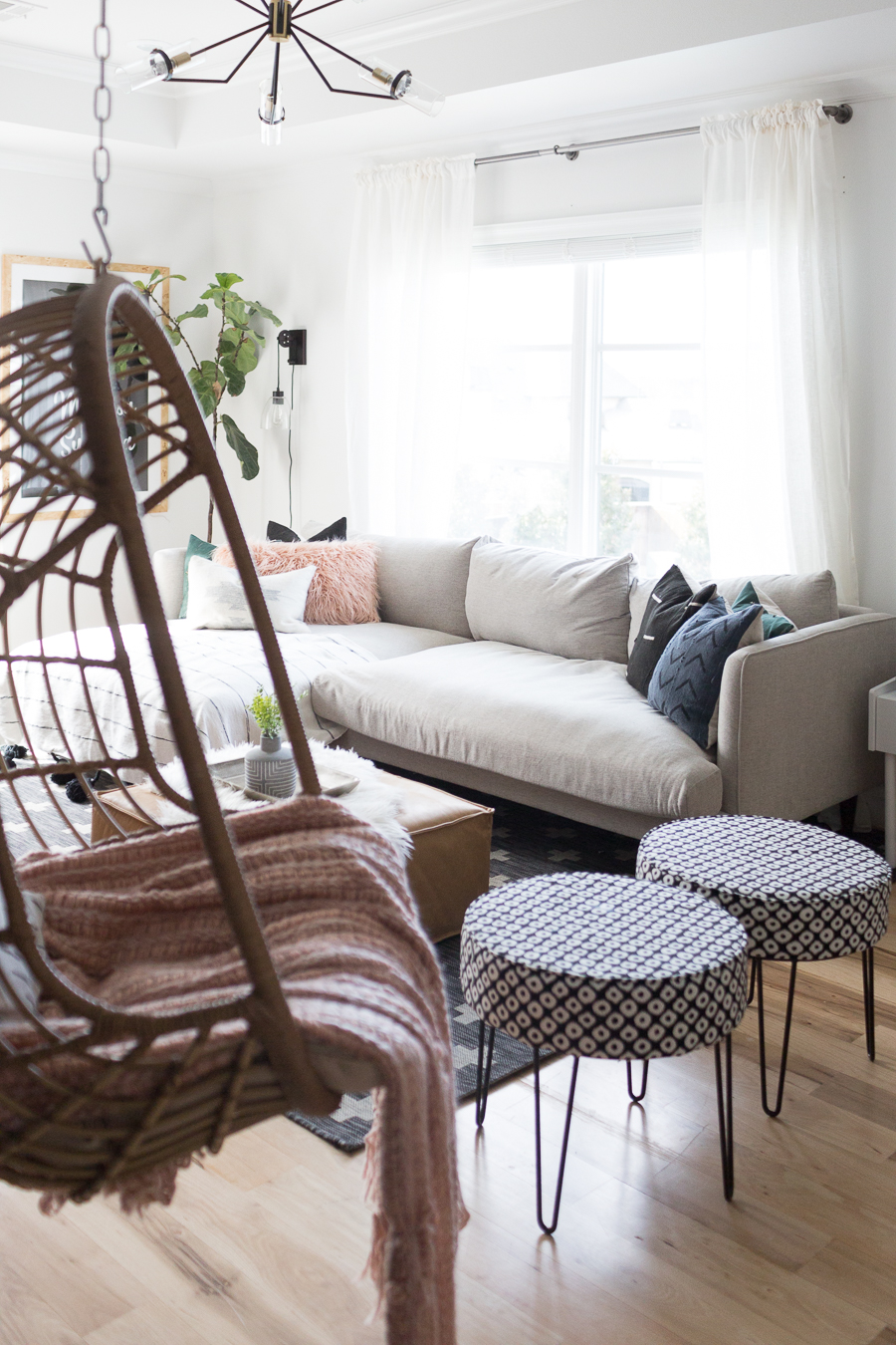 CC and Mike Teen Hangout Room Reveal with Joybird Sectional gray comfortable sectional with two round black and white ottomans and a woven hanging chair black vertical shiplap wall