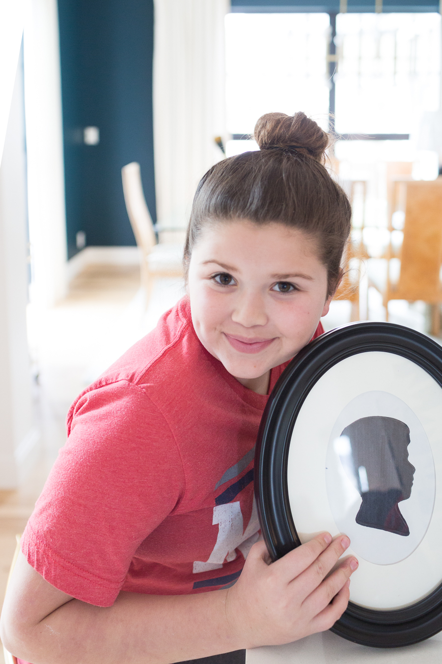 a cute girl holding up the framed silhouette