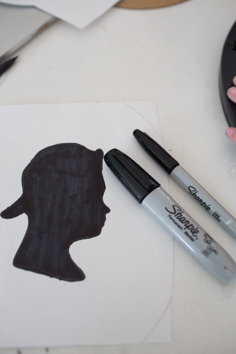 a black silhouette of a teenage boy with a backwards hat