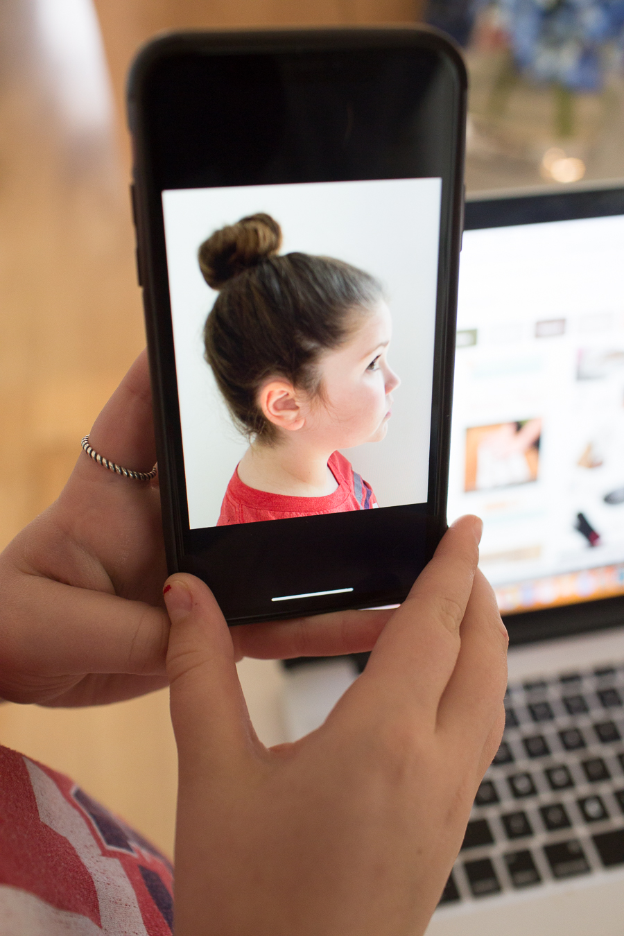 holding a phone up with a profile image of a girl