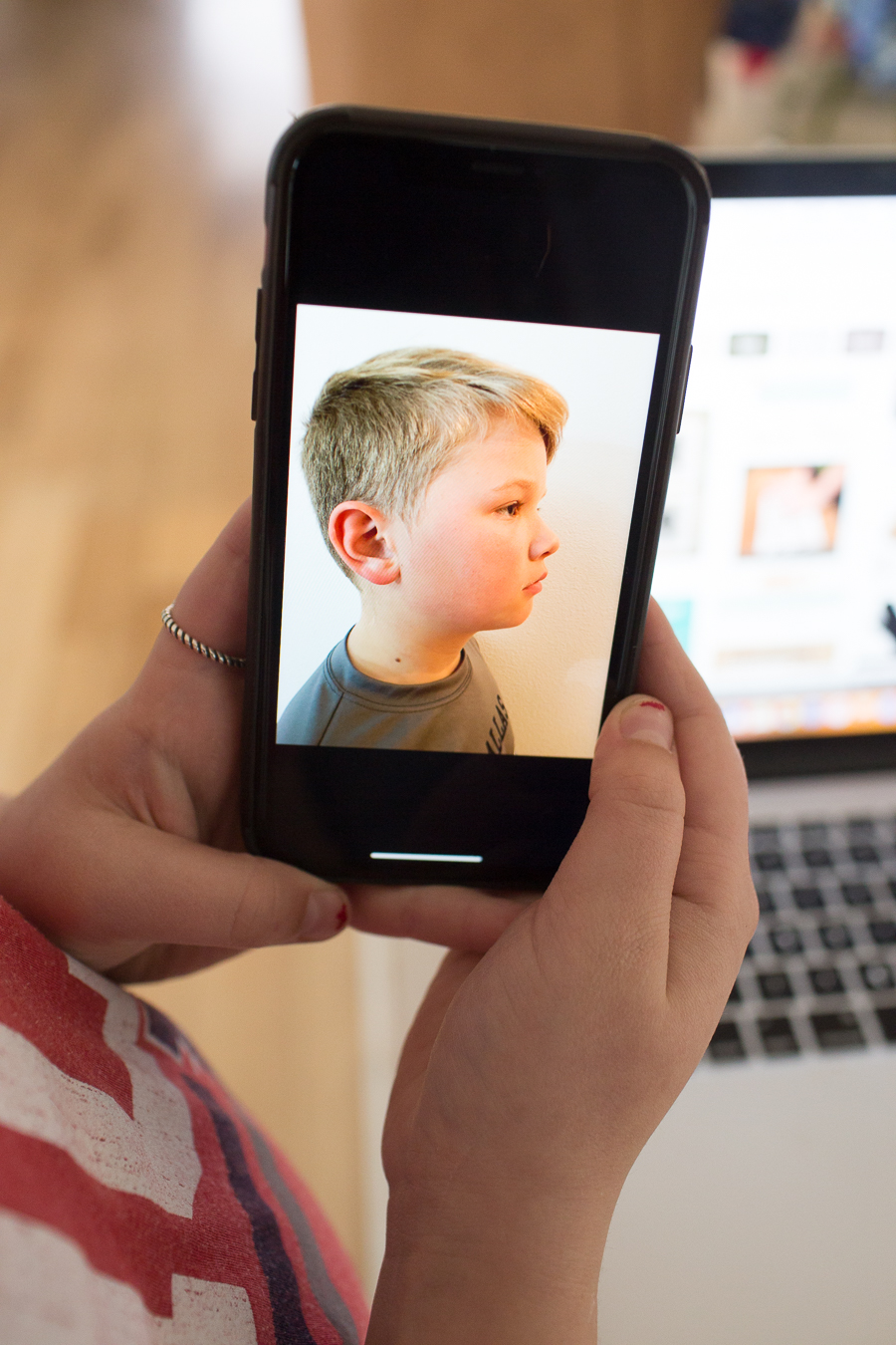 profile view of a blonde boy on an iphone