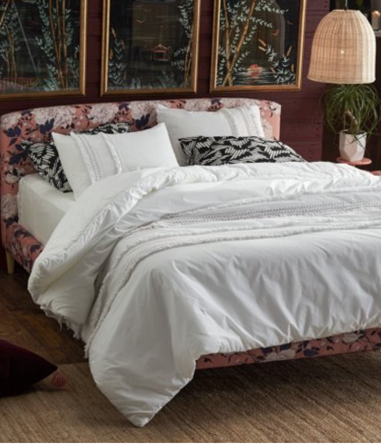 5 Tips to Decorate Your Home with Drew Barrymore Flower Home pink tufted velvet headboard and bed with white embroidered sheets white duvet set from Walmart