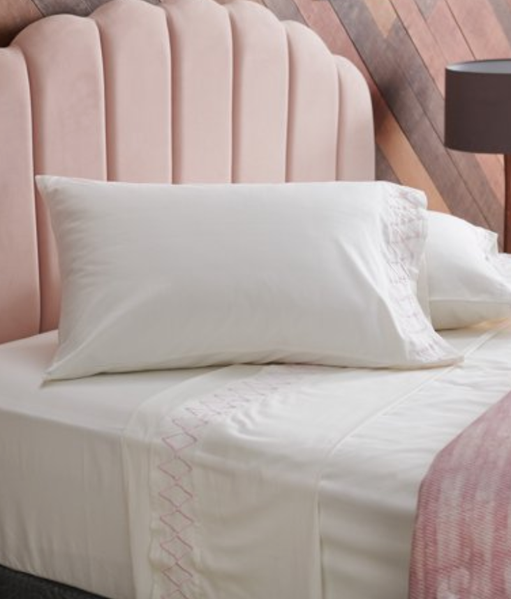 5 Tips to Decorate Your Home with Drew Barrymore Flower Home pink tufted velvet headboard and bed with white embroidered sheets