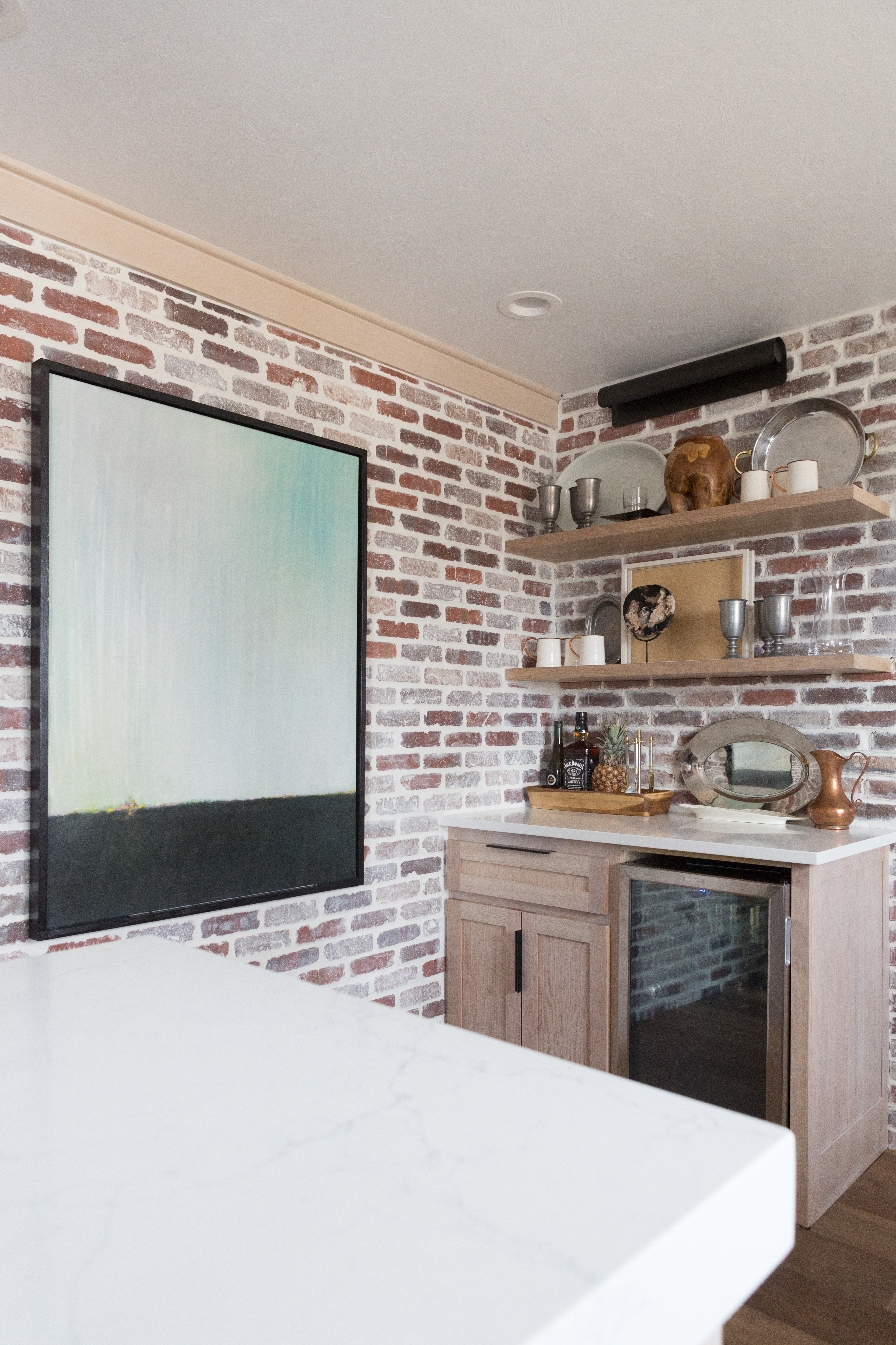 CC and Mike Kane Project Remodel Reveal brick kitchen bacskplash with a white farmhouse sink and black faucet rift sawn white oak cabinets with black hardware