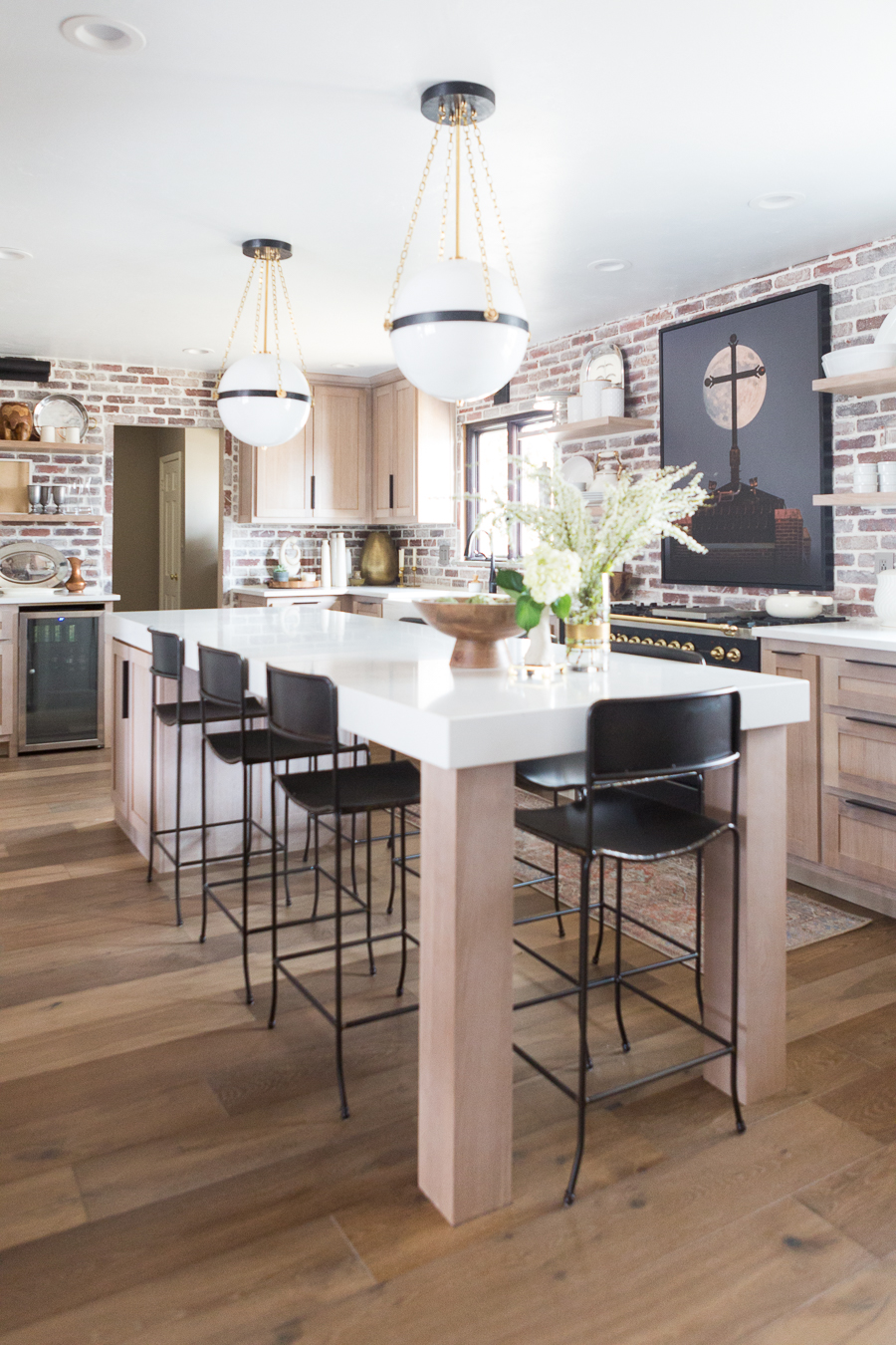 CC and Mike Kane Project Remodel Reveal brick kitchen bacskplash with a white farmhouse sink and black faucet rift sawn white oak cabinets with black hardware