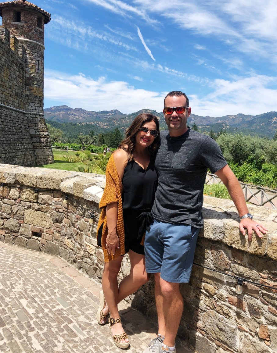 cc and mike standing in front of the beautiful mountain views with a castle