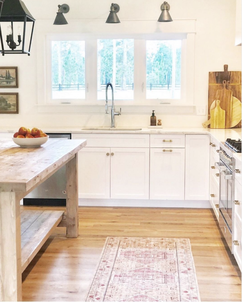 CC and Mike the SHOp labor day sales gold blush skye rug white kitchen cabinets with an all wood butcher block island and black lantern light fixtures