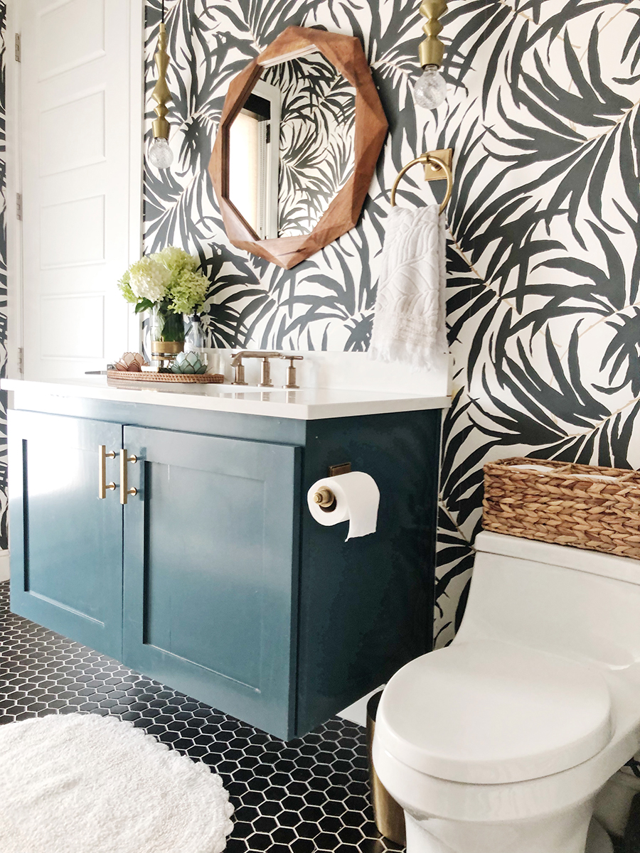 Vintage Chic Bathroom Update black hexagon floors with a green floating vanity and a wood mirror palm frond wallpaper