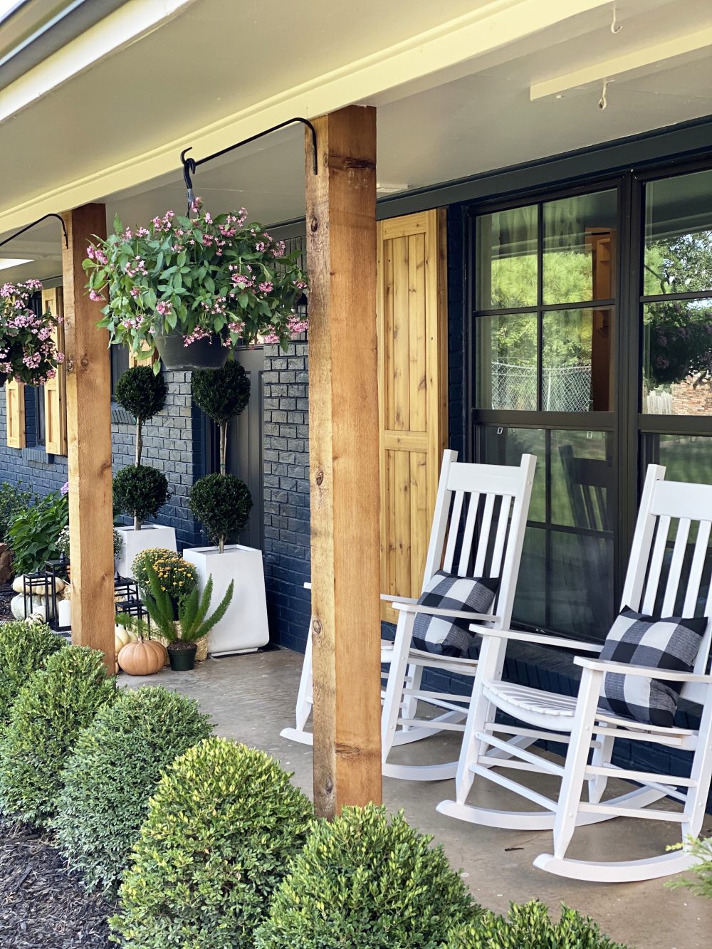 Affordable Fall Front Porch and Tabletop Decor Ideas white rcokers on front porch of a navy house with cedar shutters fall styling