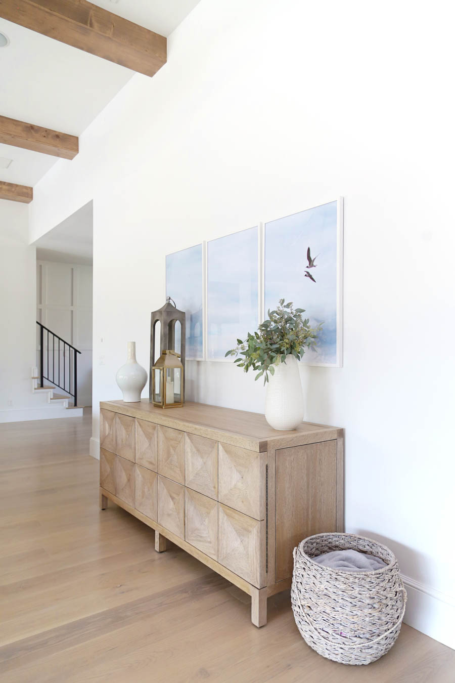 CC and Mike Frisco I Project Reveal white wall with three birds =large triptych wall art gold pottery barn lantern and wood sideboard from cc and mike the shop