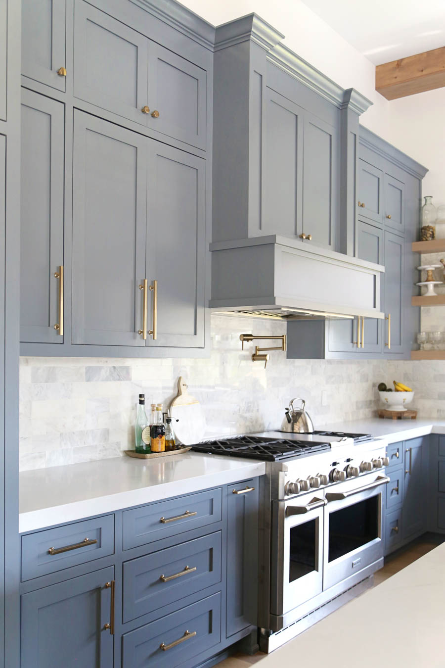 CC and Mike Frisco I Project Reveal-63 gray kitchen island and cabinets with wood bar stools quartz countertops and gold lanterns large kitchen window with gold sconces