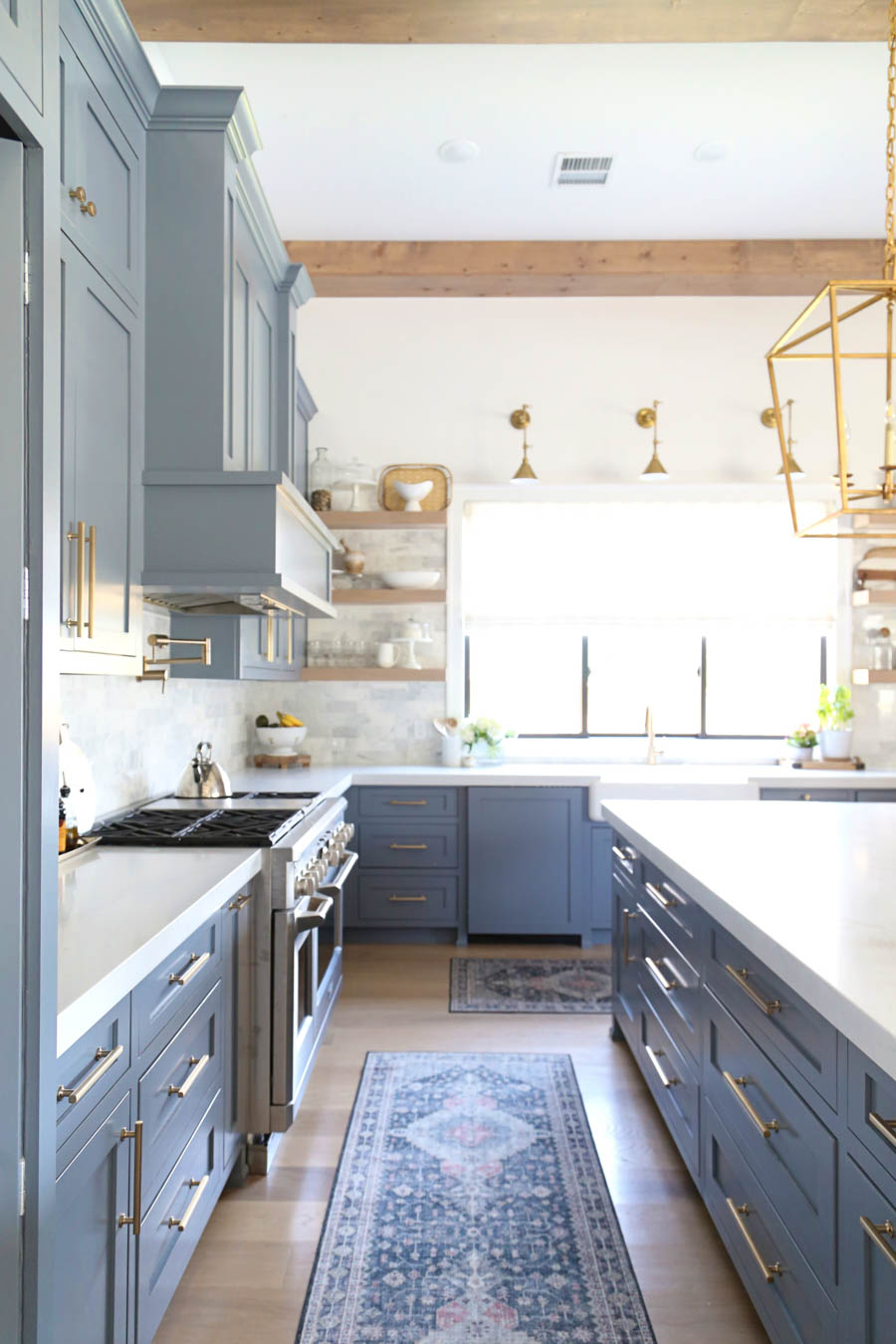 CC and Mike Frisco I Project Reveal-63 gray kitchen island and cabinets with wood bar stools quartz countertops and gold lanterns large kitchen window with gold sconces