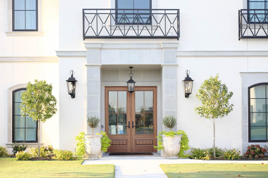 CC and Mike Frisco I Project Reveal-2 modern European exterior stucco exterior with cast stone around the entryway wood door pendant drop lantern