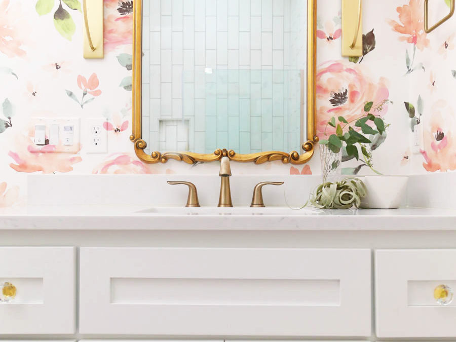 CC and Mike Frisco I Project Reveal modern girls bathroom design with  floral Anthropologie wallpaper white cabinets gold Tolouse mirror acrylic  and gold hardware on a white bathroom vanity and white hexagon
