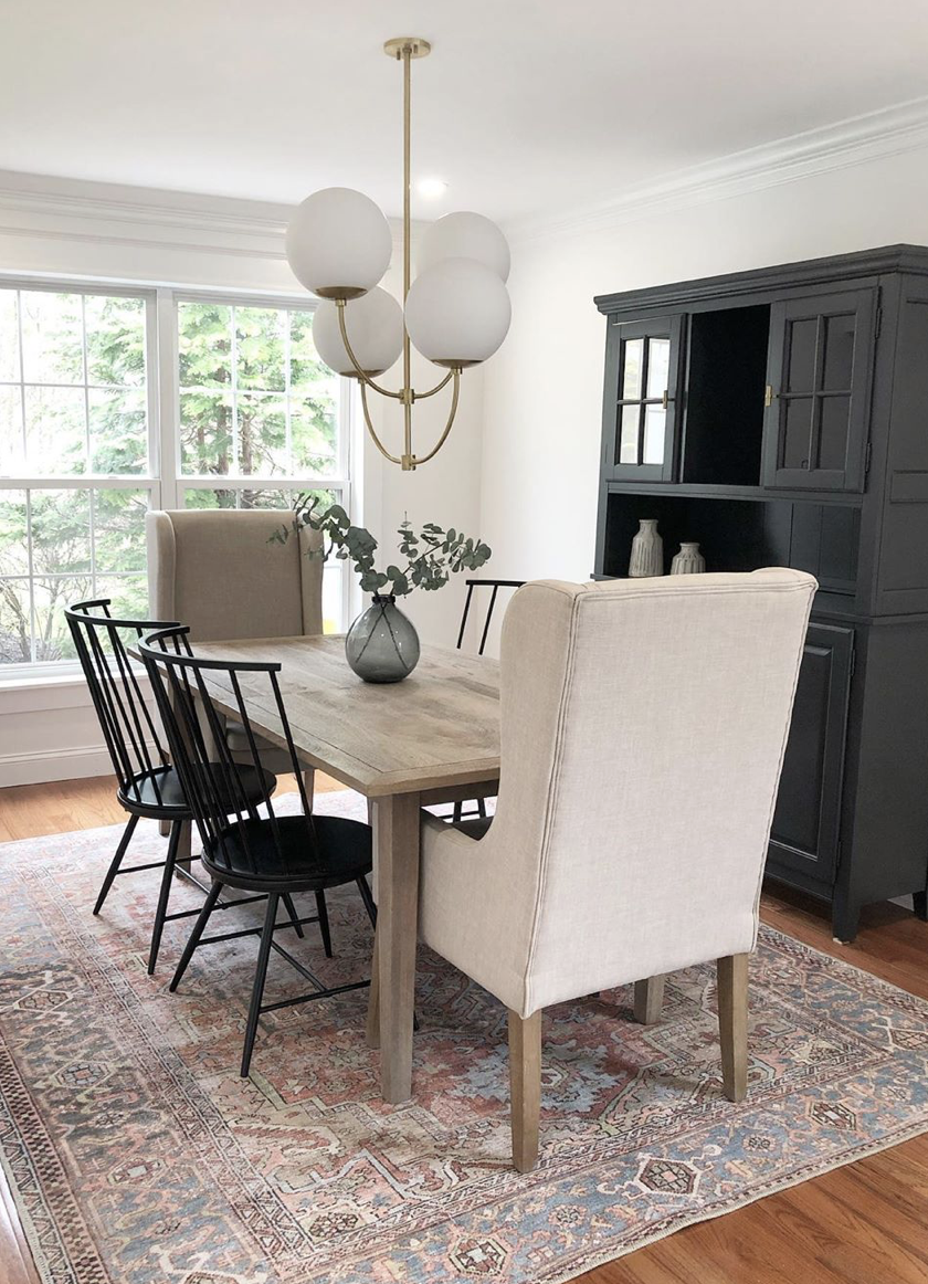 How-to-Update-Your-Rugs-for-Spring olive charcoal Layla with a wood Dining room table black spindle dining chairs and upholstered linen dining chairs