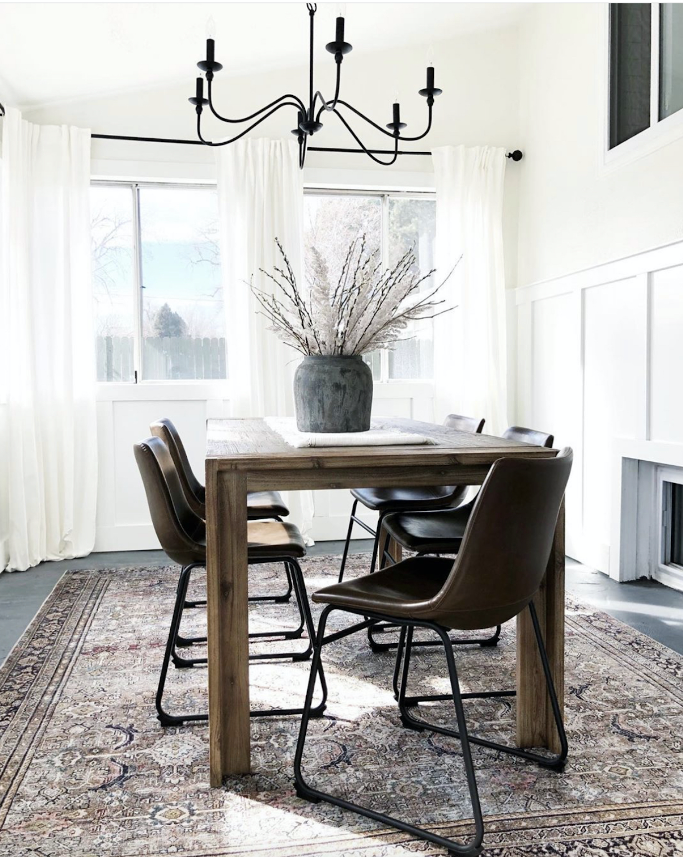 How-to-Update-Your-Rugs-for-Spring olive charcoal Layla with a wood Dining room table black spindle dining chairs and upholstered linen dining chairs