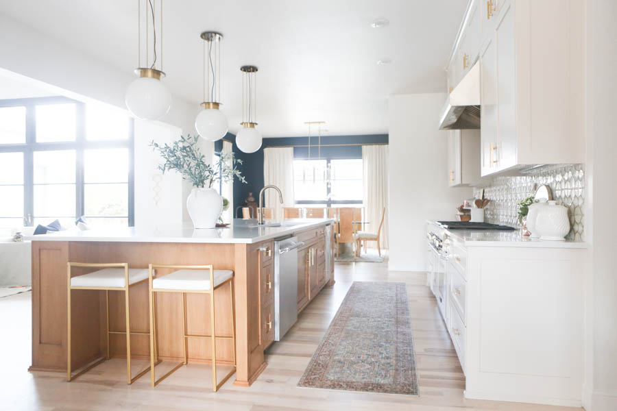 CC and MIke Kitchen Remodel Reveal large natural wood island with quartz countertops and gold bar stools black and gold pendants Ann sacks patterned backsplash gold Brizo faucet large Kallista stainless steel sink open floorpan