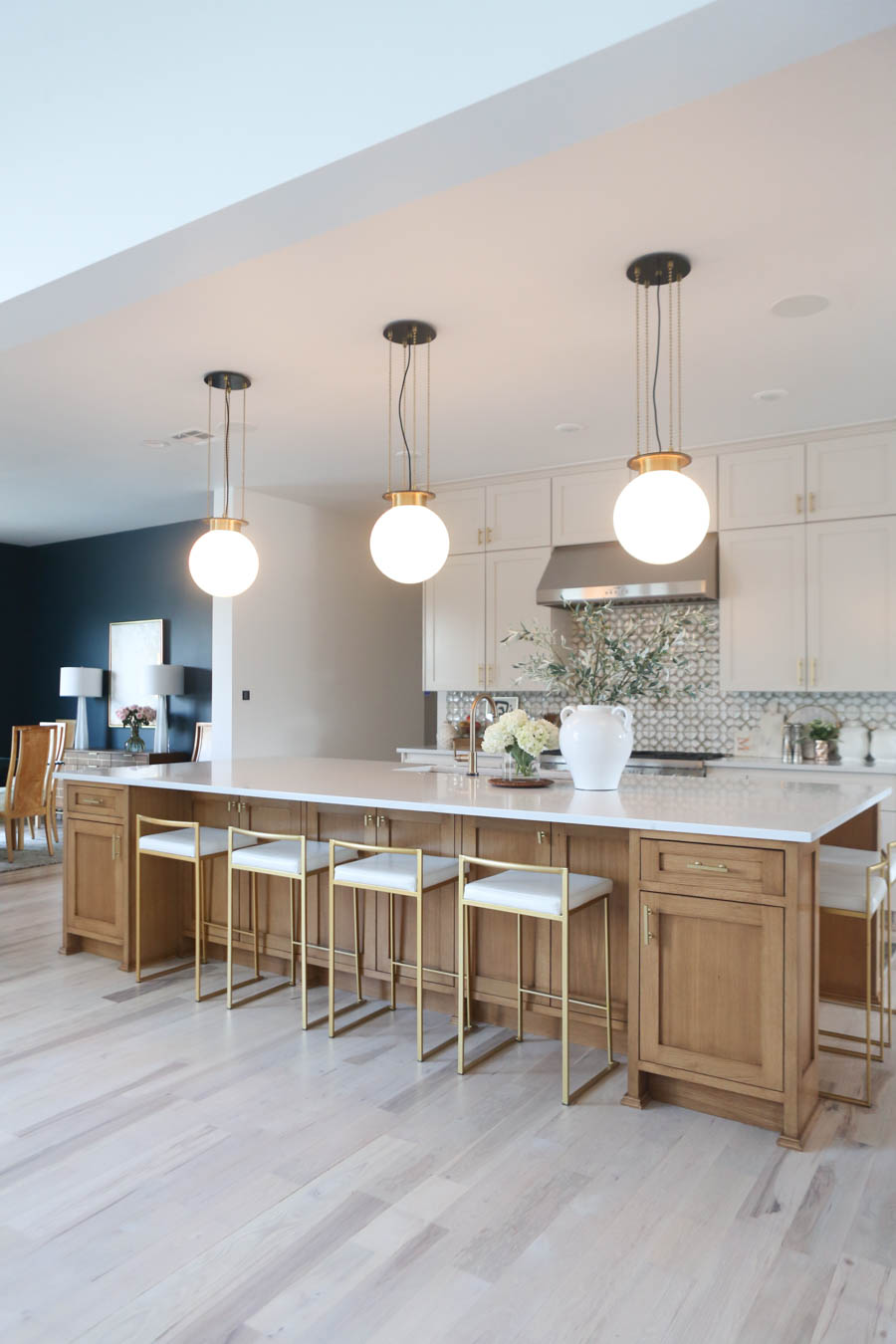 CC and MIke Kitchen Remodel Reveal large natural wood island with quartz countertops and gold bar stools black and gold pendants Ann sacks patterned backsplash gold Brizo faucet large Kallista stainless steel sink open floorpan