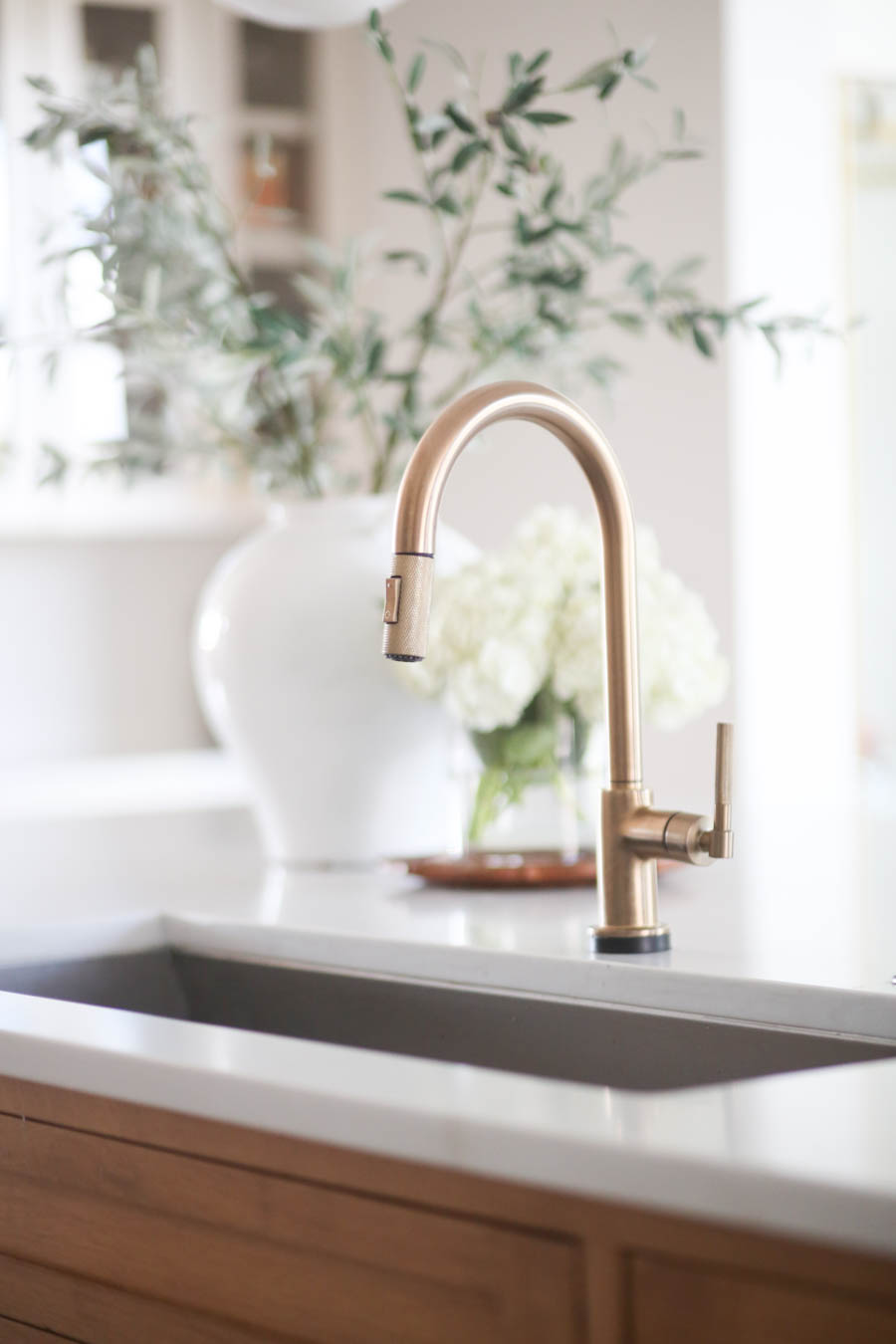 CC and MIke Kitchen Remodel Reveal large natural wood island with quartz countertops and gold bar stools black and gold pendants Ann sacks patterned backsplash gold Brizo faucet large Kallista stainless steel sink open floorpan