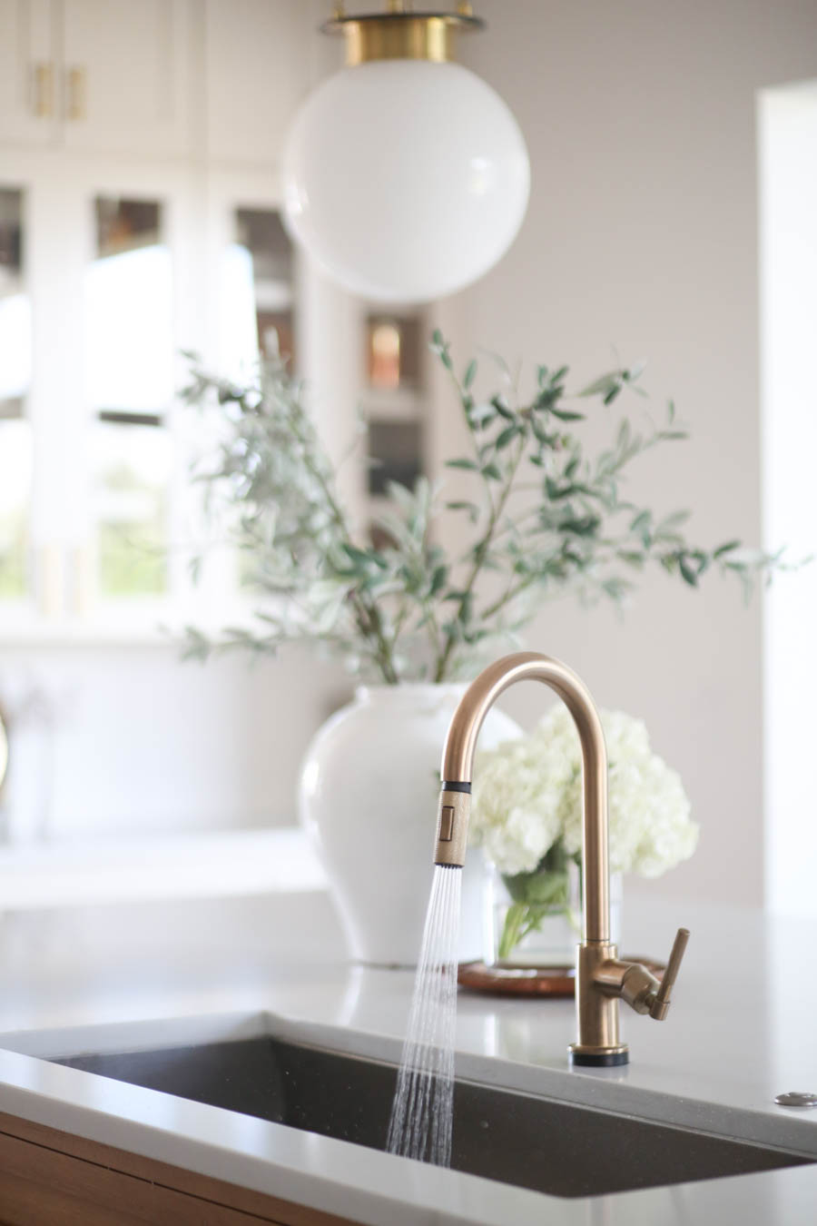 CC and MIke Kitchen Remodel Reveal large natural wood island with quartz countertops and gold bar stools black and gold pendants Ann sacks patterned backsplash gold Brizo faucet large Kallista stainless steel sink open floorpan