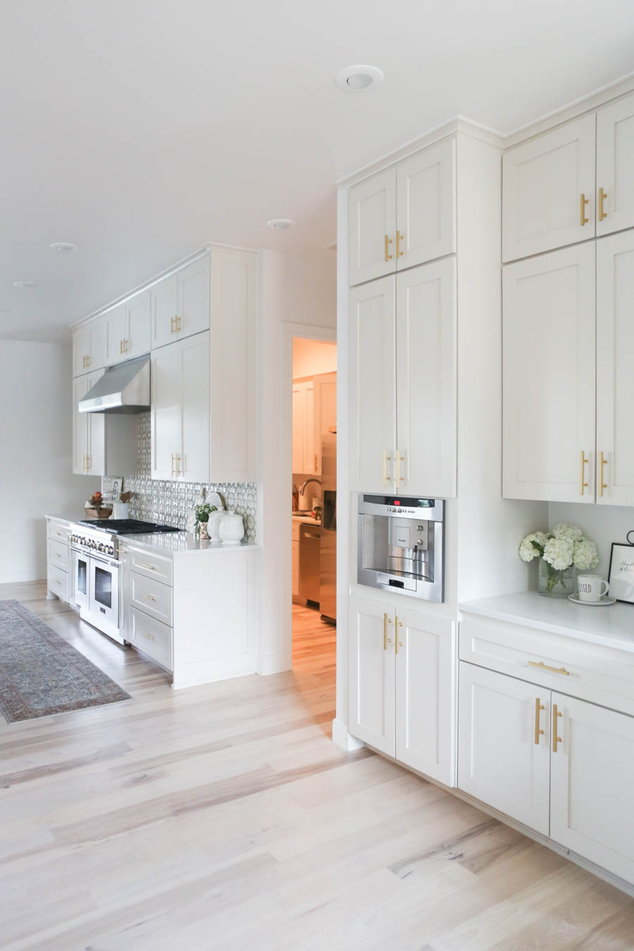 CC and MIke Kitchen Remodel Reveal large natural wood island with quartz countertops and gold bar stools black and gold pendants Ann sacks patterned backsplash gold Brizo faucet large Kallista stainless steel sink open floorpan