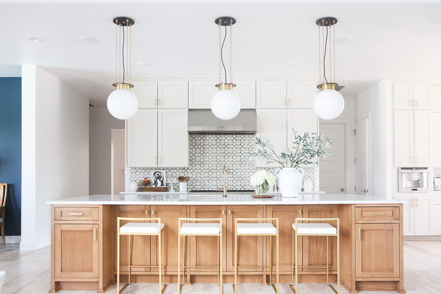 CC and MIke Kitchen Remodel Reveal large natural wood island with quartz countertops and gold bar stools black and gold pendants Ann sacks patterned backsplash gold Brizo faucet large Kallista stainless steel sink open floorpan