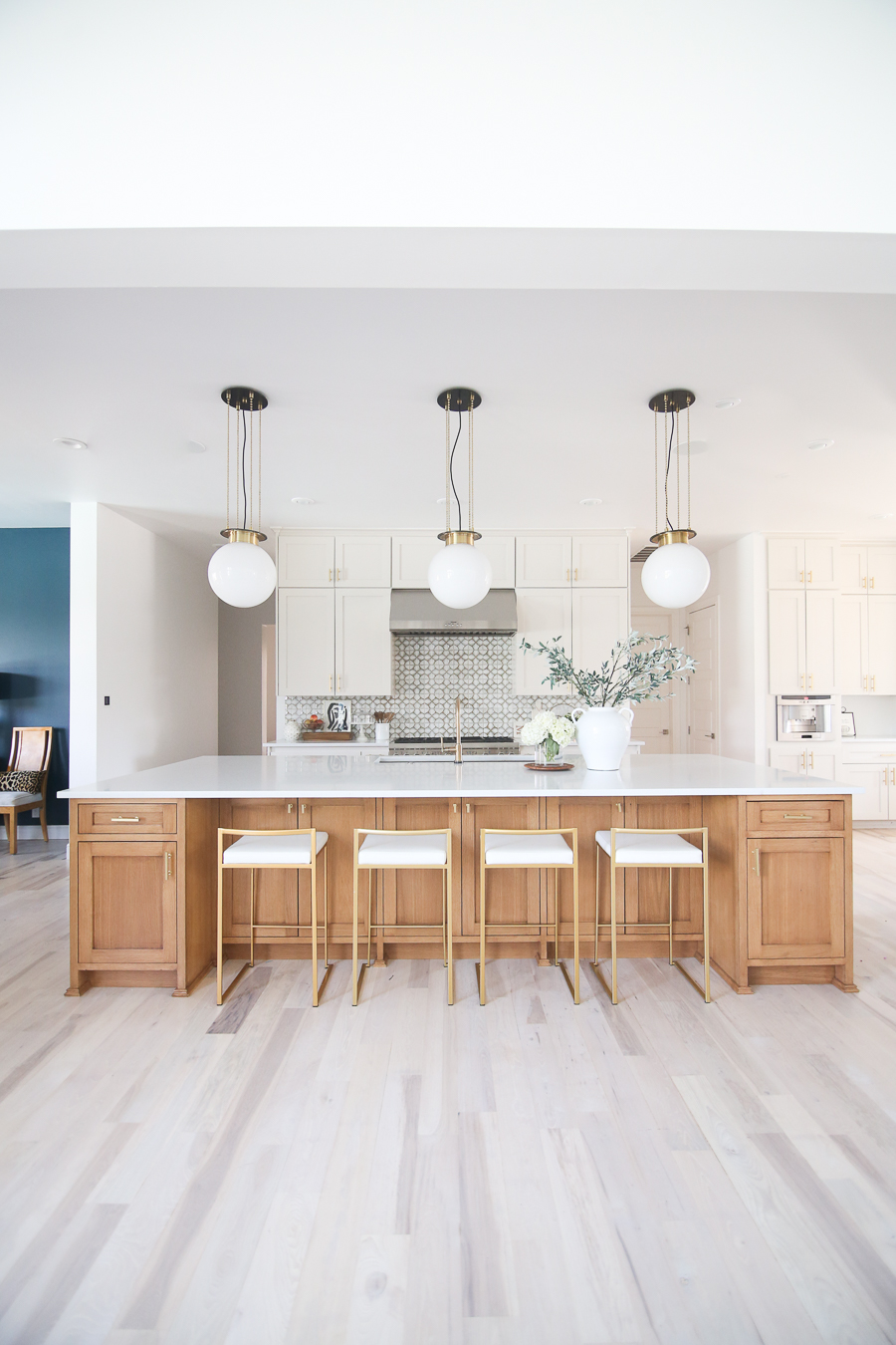 CC and MIke Kitchen Remodel Reveal large natural wood island with quartz countertops and gold bar stools black and gold pendants Ann sacks patterned backsplash gold Brizo faucet large Kallista stainless steel sink open floorpan