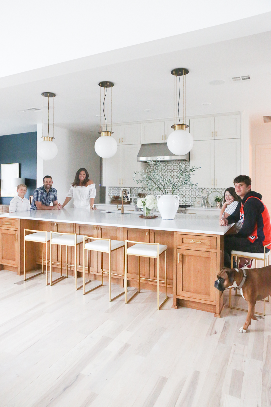 CC and MIke Kitchen Remodel Reveal large natural wood island with quartz countertops and gold bar stools black and gold pendants Ann sacks patterned backsplash gold Brizo faucet large Kallista stainless steel sink open floorpan