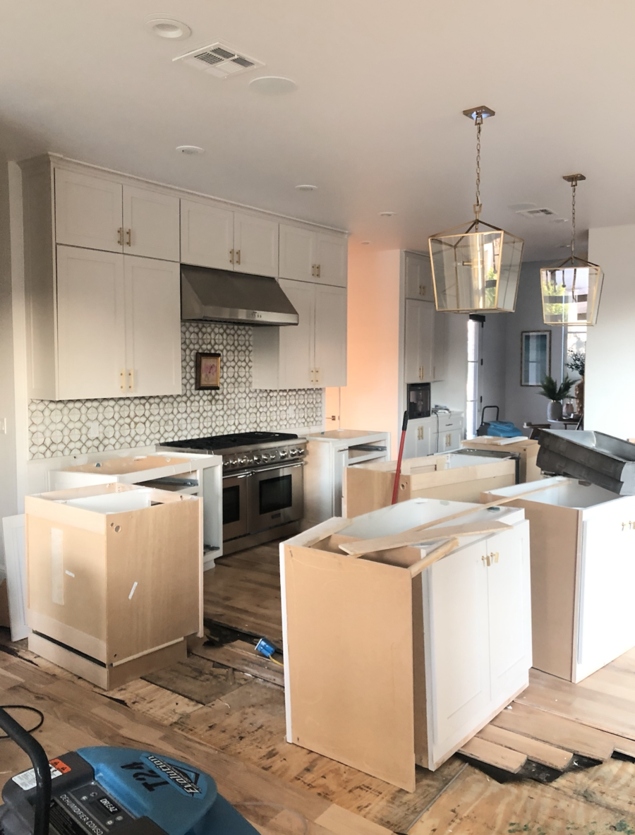 CC and MIke Kitchen Remodel Reveal large natural wood island with quartz countertops and gold bar stools black and gold pendants Ann sacks patterned backsplash gold Brizo faucet large Kallista stainless steel sink open floorpan