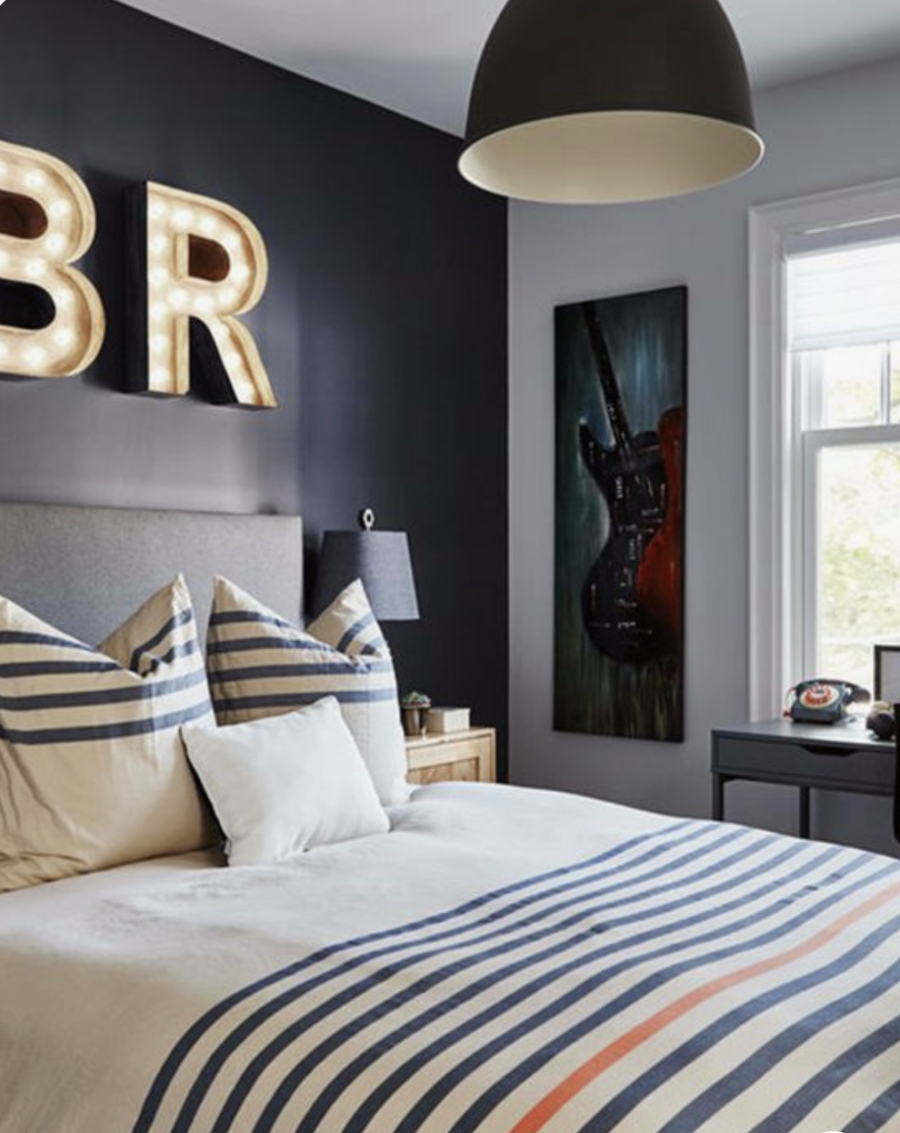 5 Tips for Boys Bedroom Design navy accent wall large metal striped bedding wood bed bicycle hanging on the wal